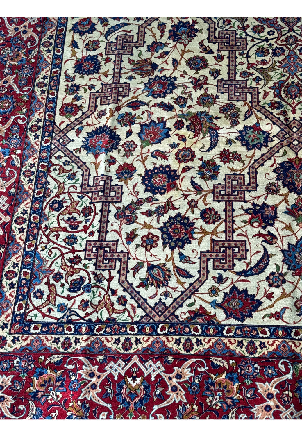 Close-up of the Persian Isfahan rug's border corner, featuring detailed floral motifs and geometric designs.