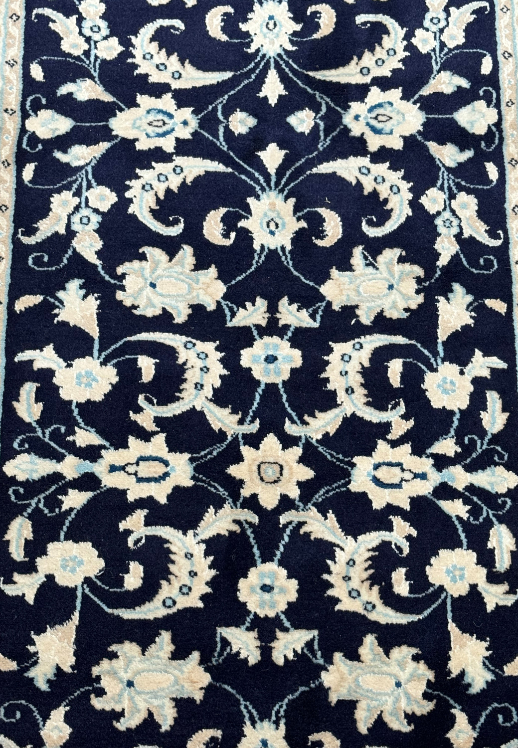 Detailed view of the Persian Nain Runner's central design with focus on the floral motifs and color contrast.