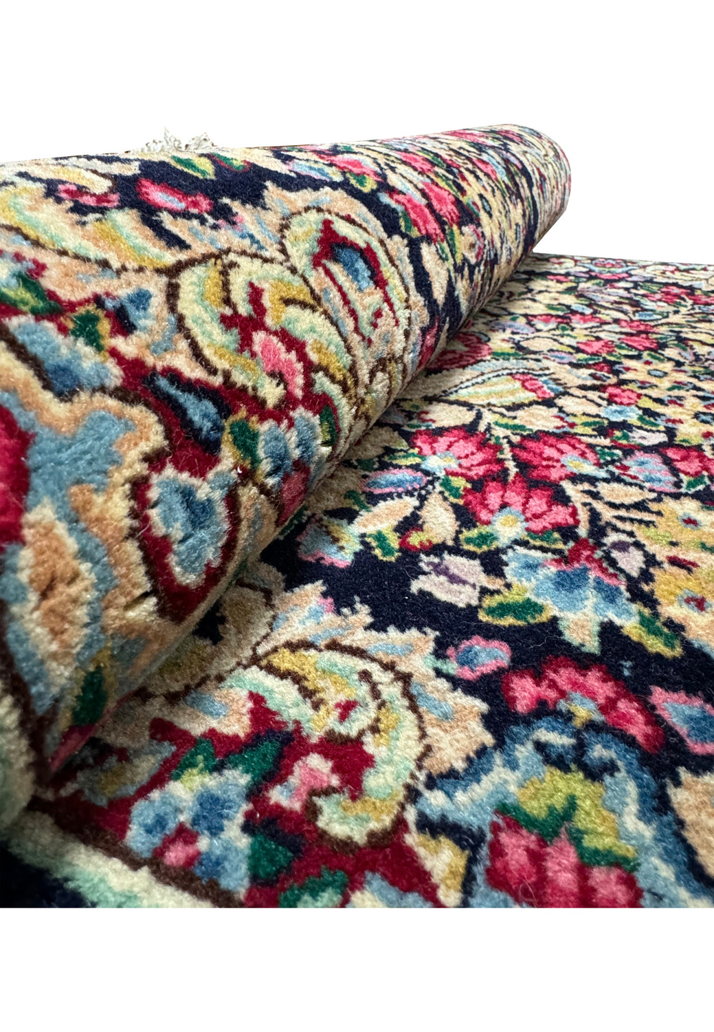 Detailed view of the Persian Kerman rug's pattern, featuring a variety of flowers and foliage in rich, bold colors.