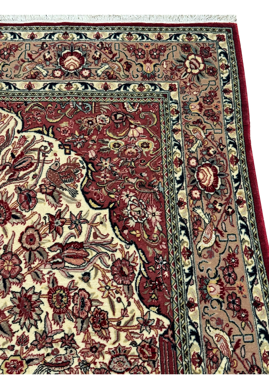 Close-up of the Persian Qum rug's elaborate border with intertwined floral and vine patterns in deep burgundy and navy, set against a cream backdrop.