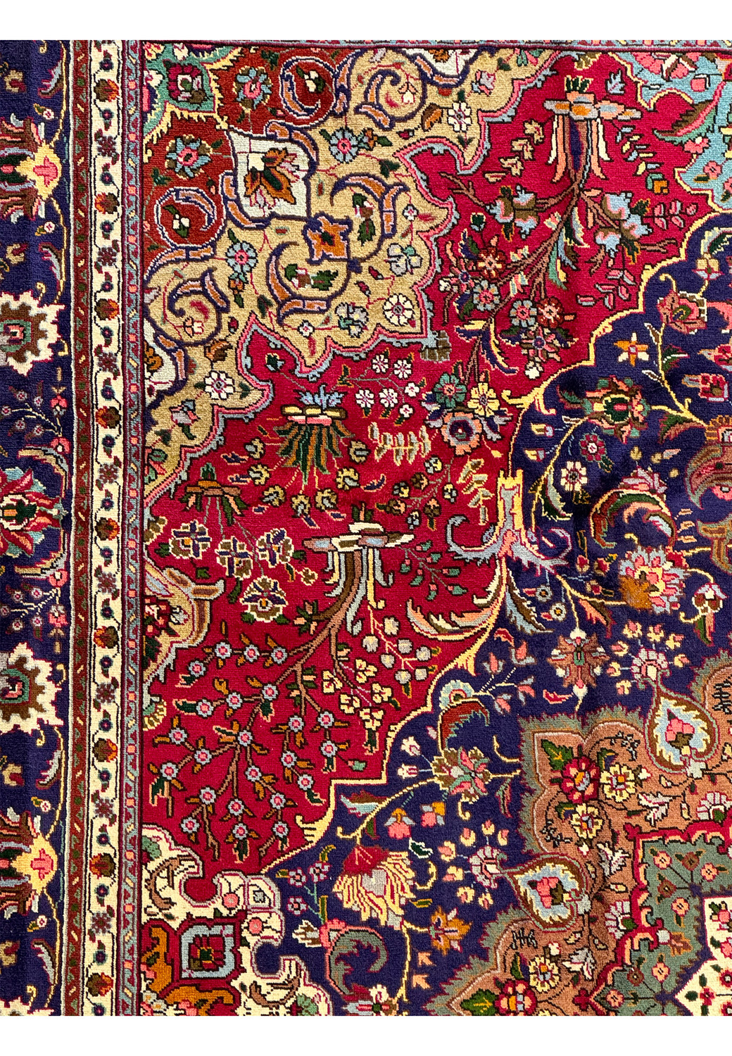 Mid-section close-up of the Persian Geometric Tabriz Rug illustrating the detailed floral elements and color contrasts against the dark blue field.