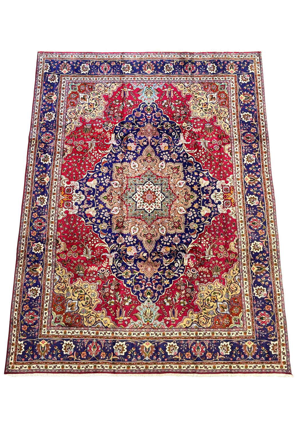 Overhead view of a 9'8" x 13'4" Persian Geometric Tabriz Rug showcasing a navy blue field with a central cream medallion surrounded by intricate floral patterns and a rich red perimeter.