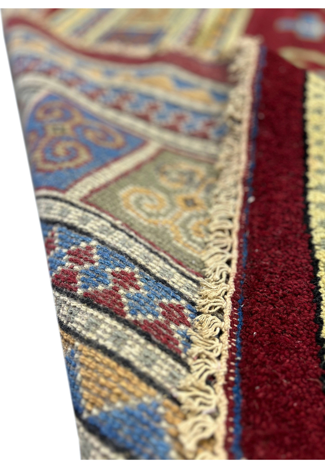 This image focuses on the edge of the Kazak rug, showing the fringe and the transition from the central pattern to the border. The detailed weave and color blending are visible.