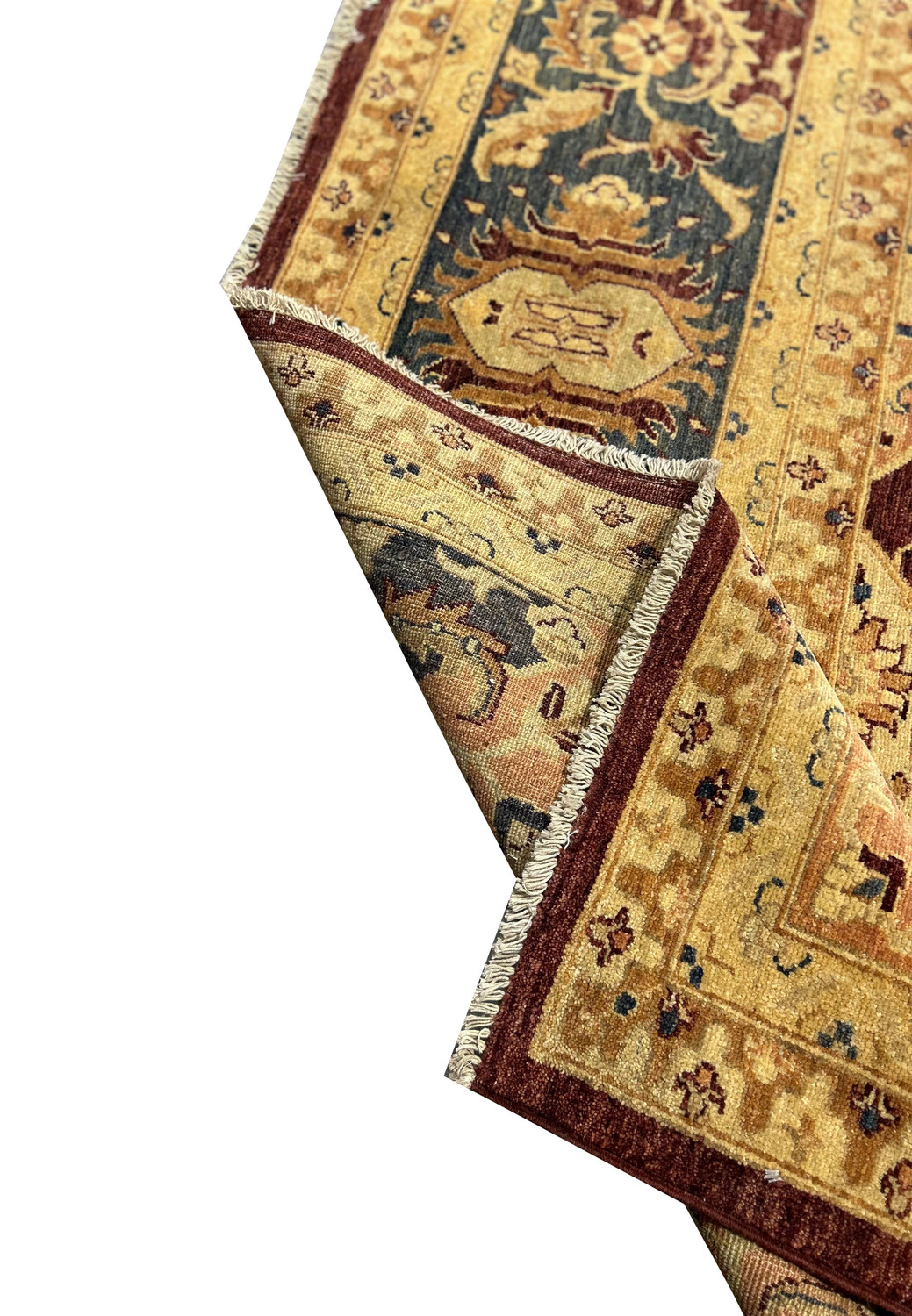 A view of the Agra rug corner, showing the fringe and detailed border. The intricate patterns and the softness of the natural wool fibers are highlighted, showcasing the rug's premium quality.