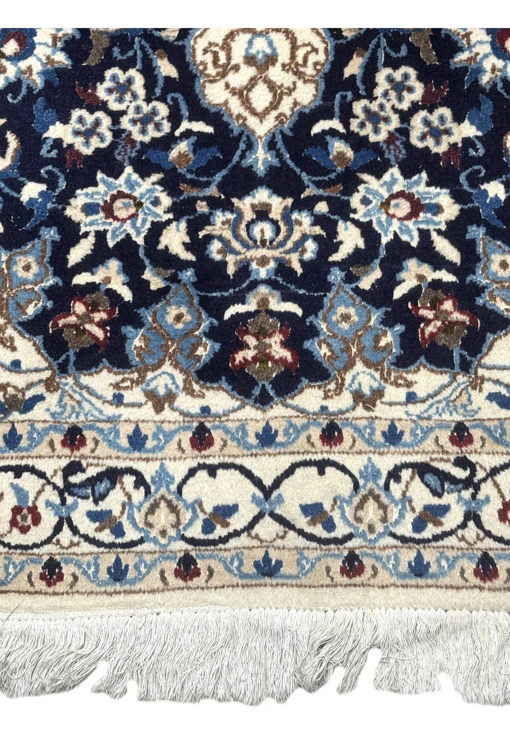 Bottom border of Persian Nain rug with fringes and floral trim