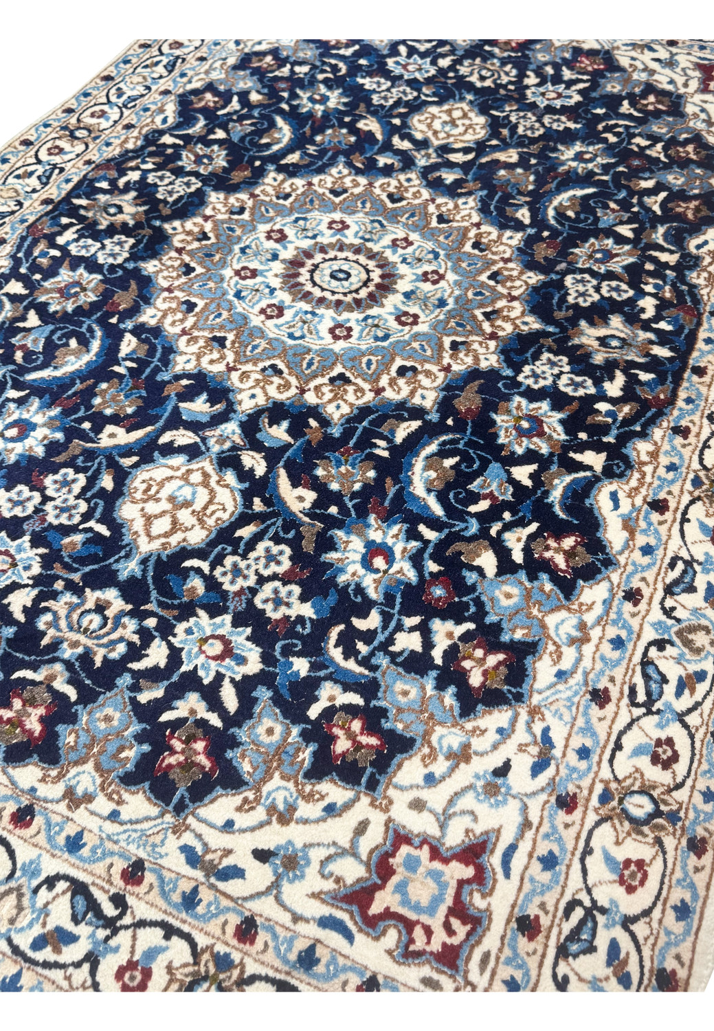 Angle view showing medallion and floral vines in rich tones Nain Persian Rug