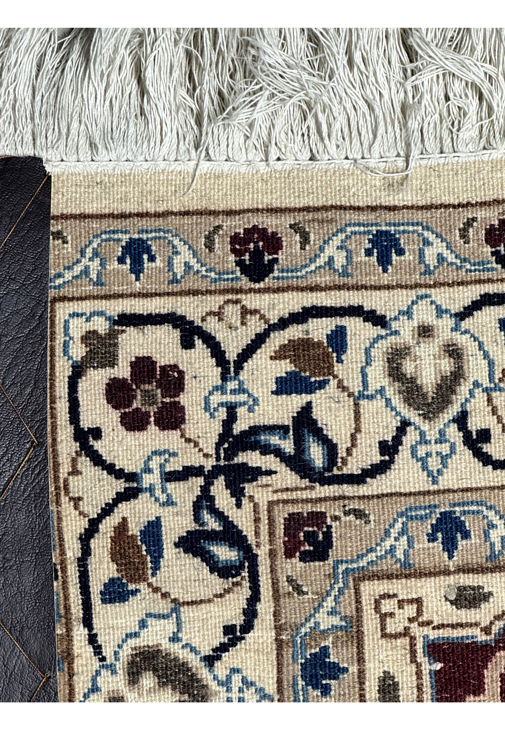 Close-up of rug's underside showing detailed knotting and fringe