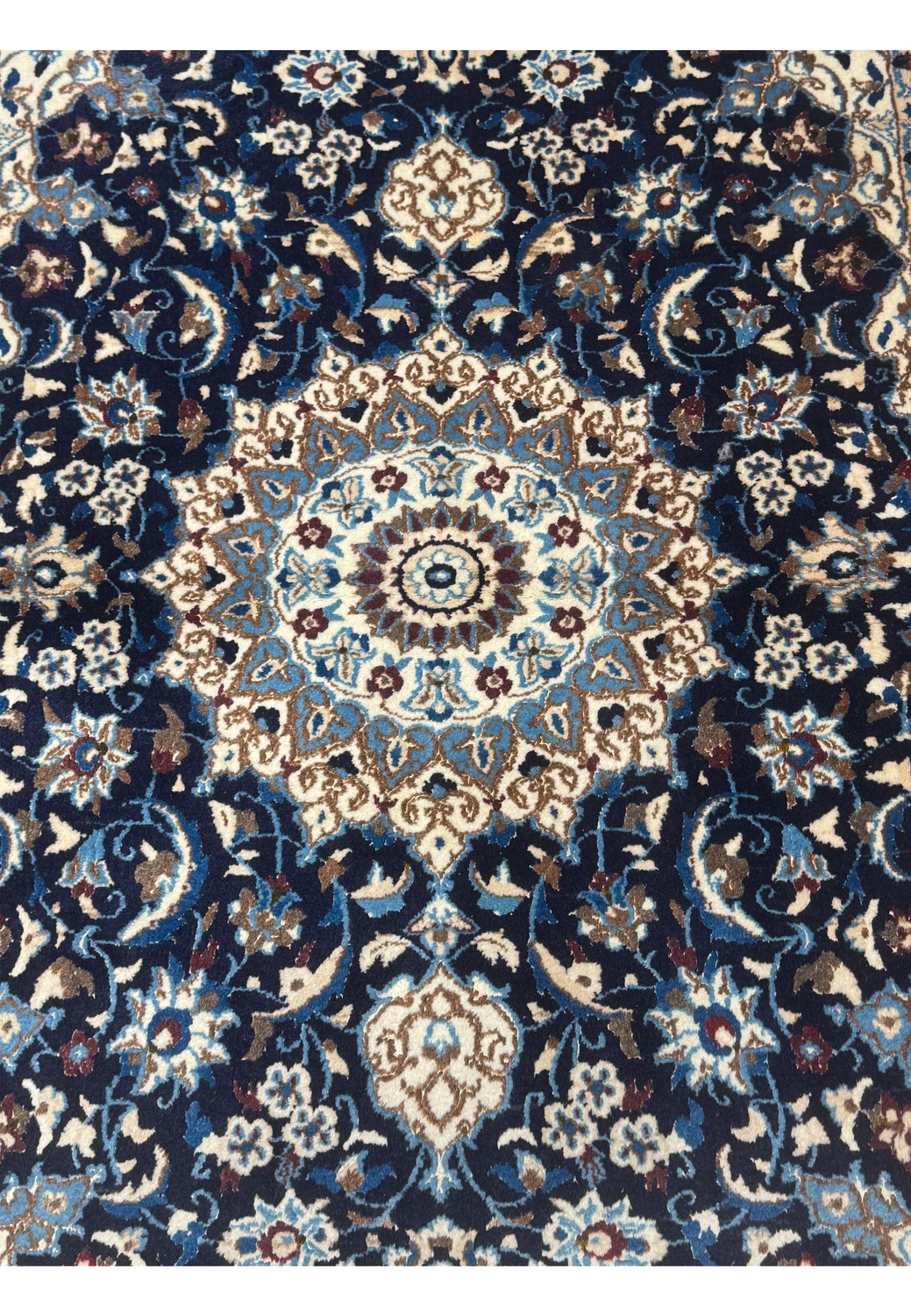 Close-up of central medallion on Persian Nain rug with blue and cream details