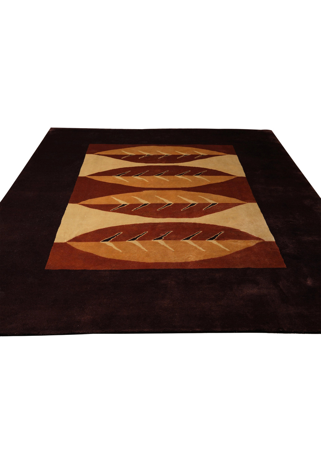 Top view of abstract leaf pattern in earth tones on wool rug