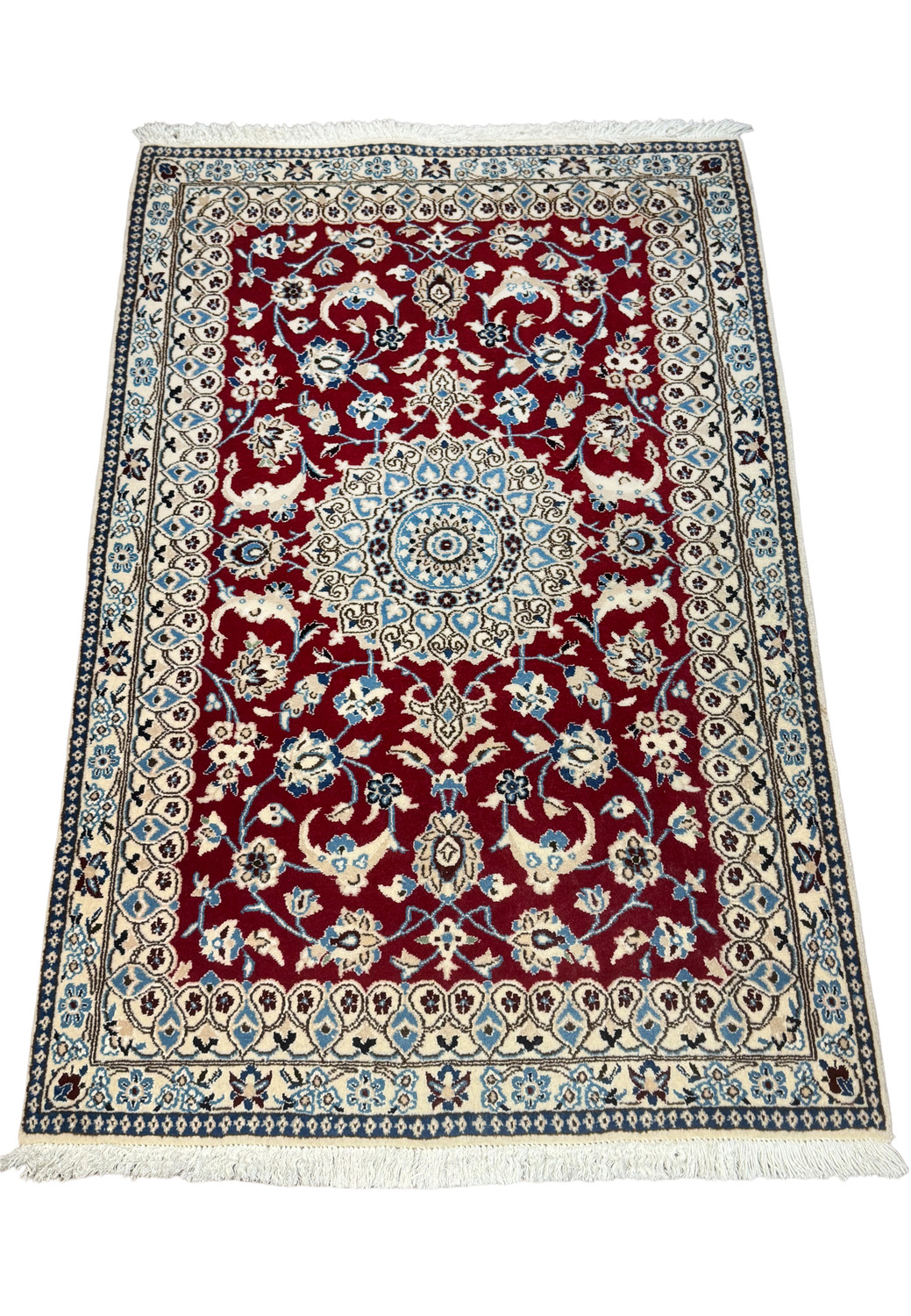 Angled view of Persian Nain rug highlighting medallion and red field