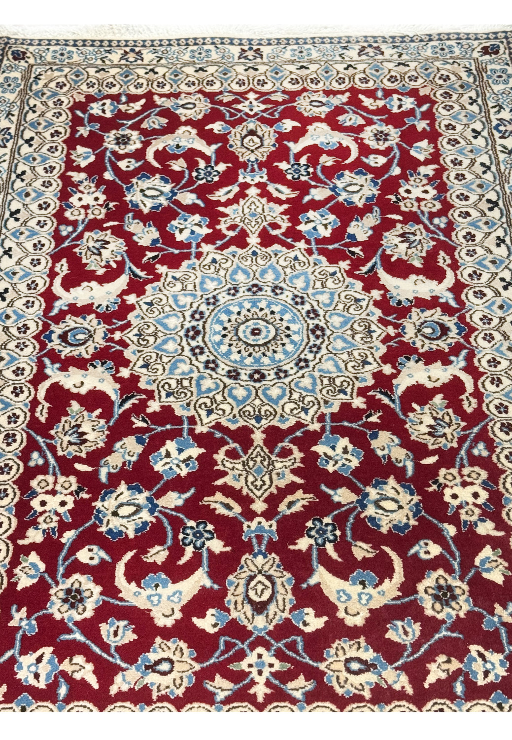 Close-up of central medallion in ivory and blue on red background