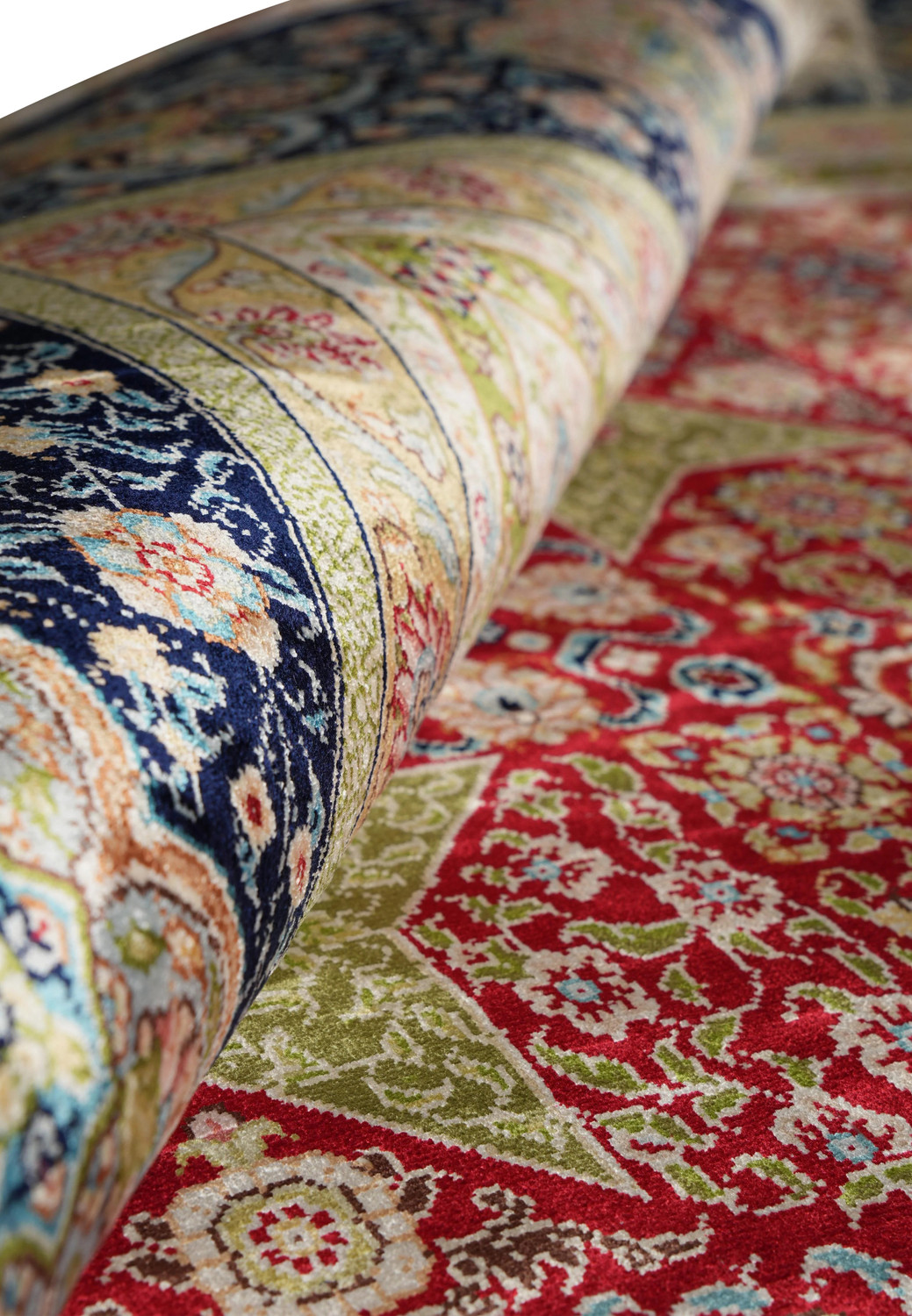 Rolled view of vintage signed 6x9 Chinese silk rug with luminous sheen and detailed motifs