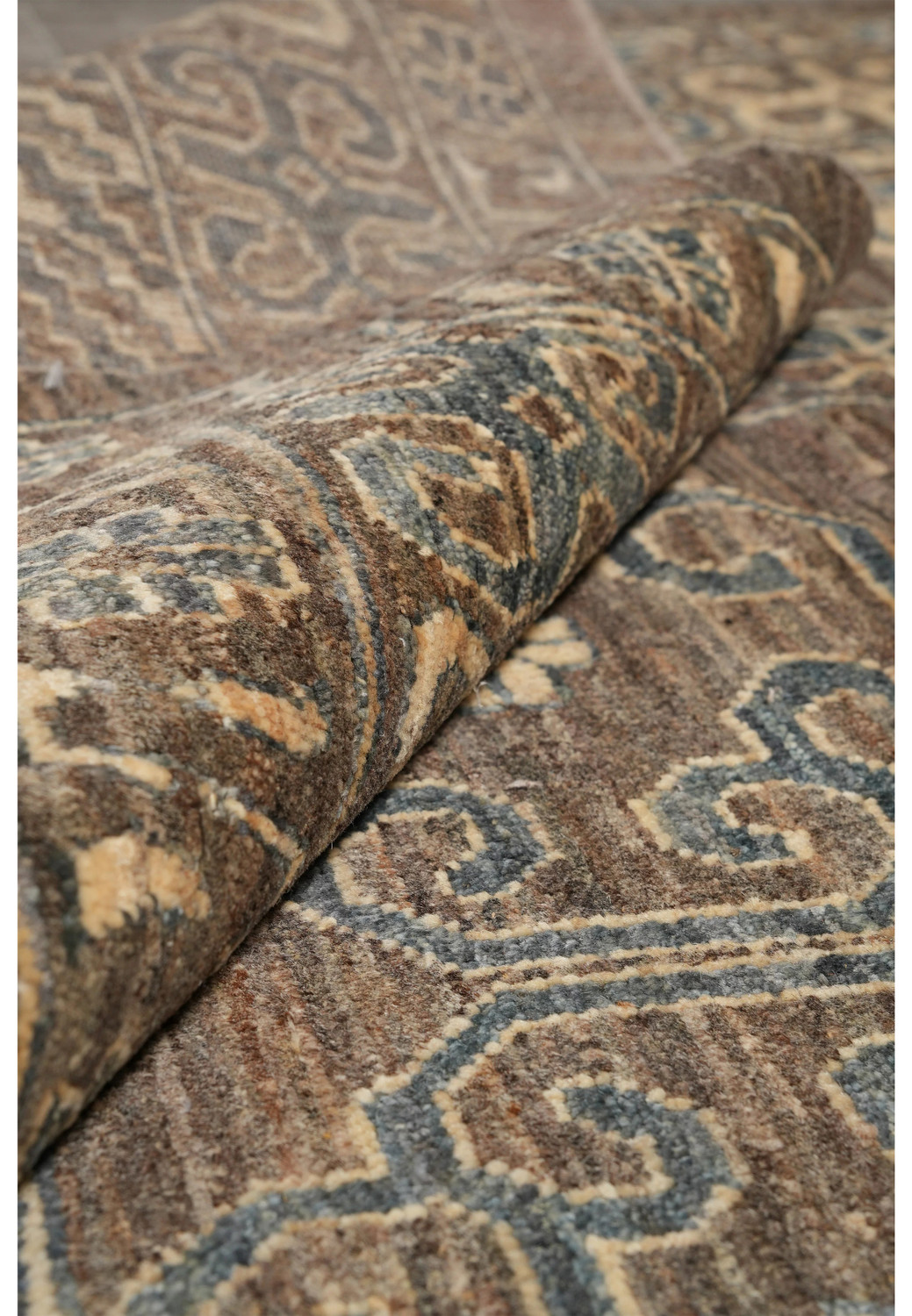 Zigler Transitional Rug rolled corner highlighting wool pile, earthy brown and grey tones with beige accents.