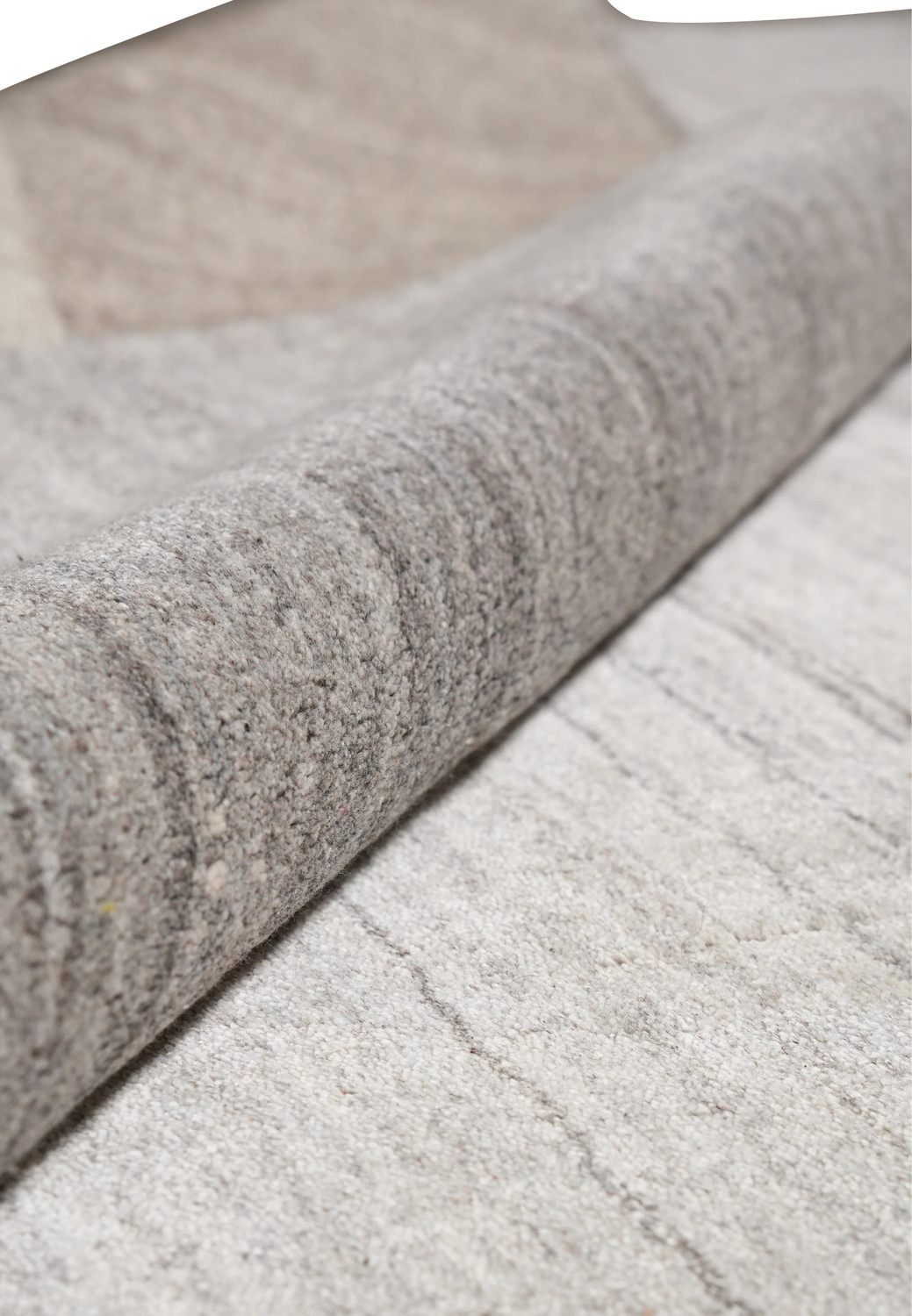 Rolled view of 9.2 x 12.1 plain solid gray wool rug highlighting texture