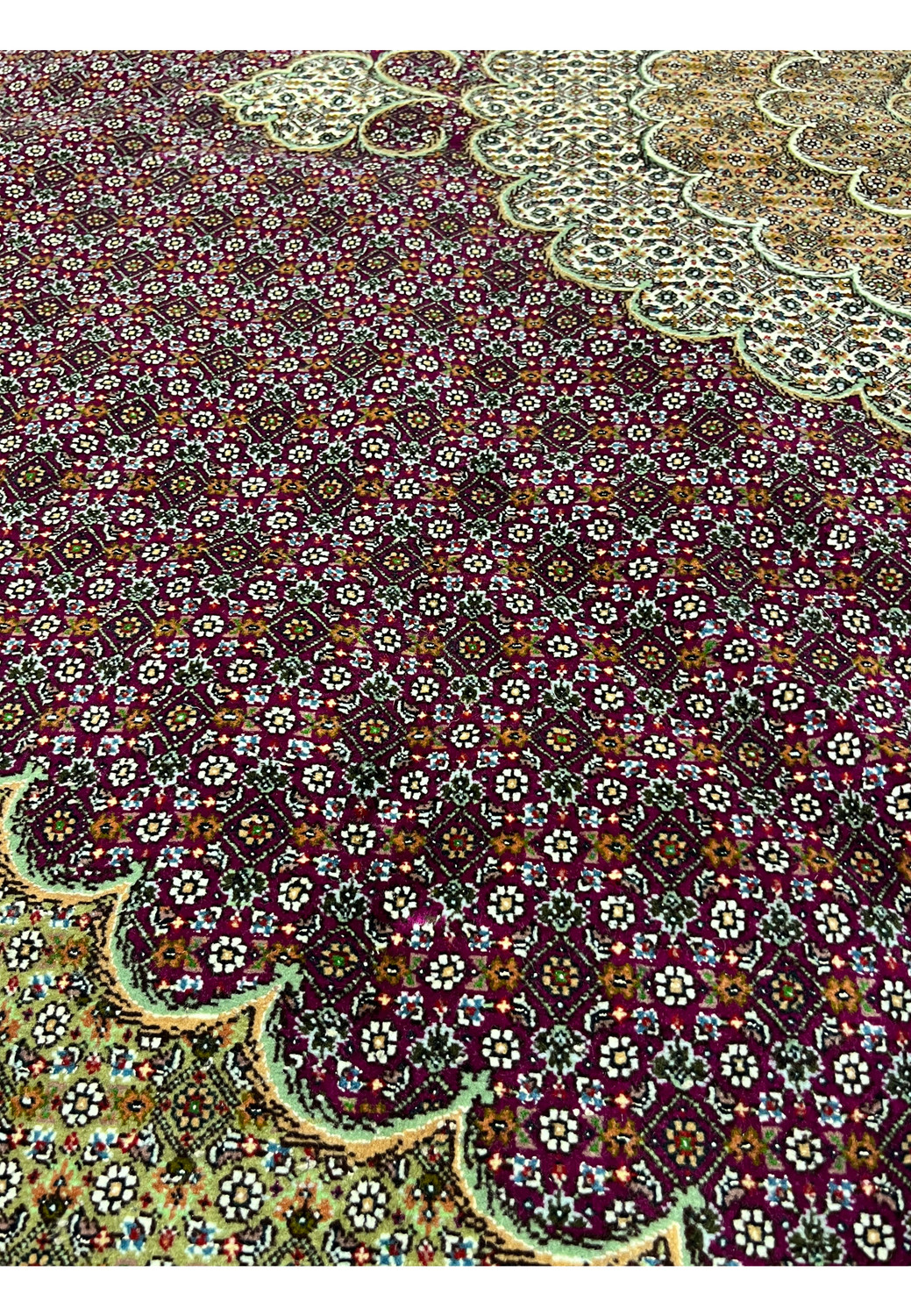 Close-up of Tabriz 50 Raj rug colors with burgundy field, ivory floral details, black outlines, and subtle blue silk highlights