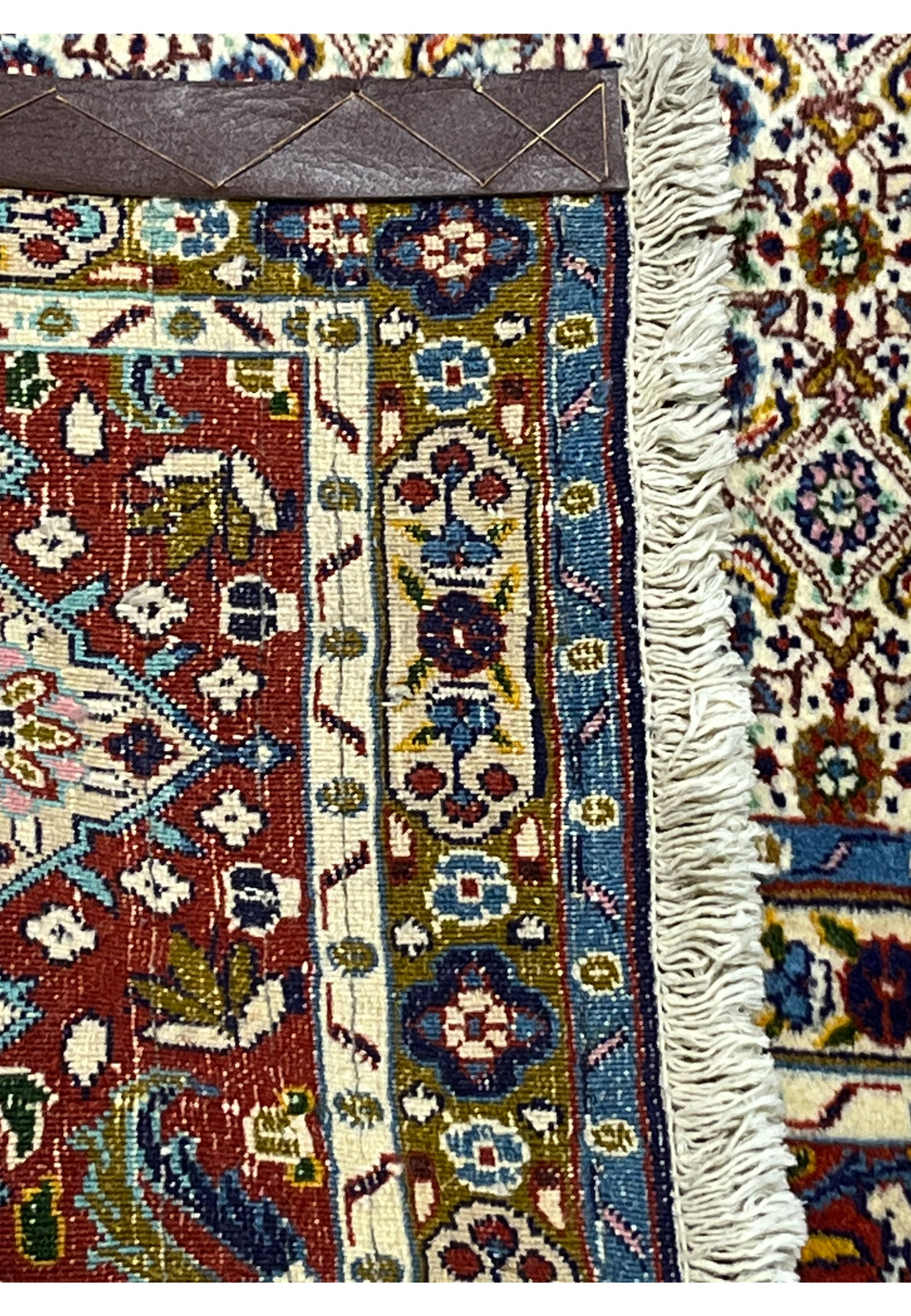 Backside of Persian Moud rug showing hand-knotted weave and cotton foundation