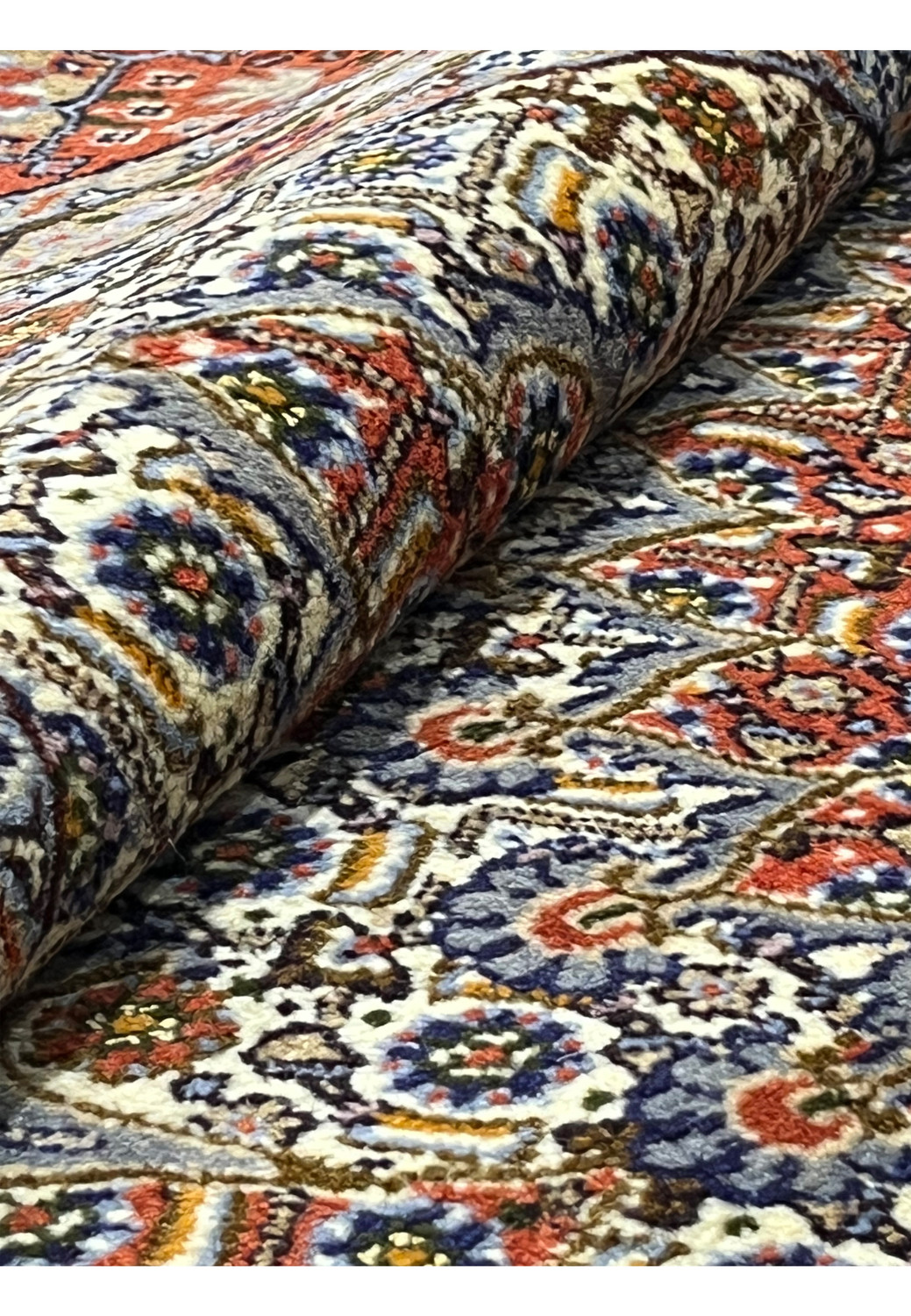 Rolled section of the 8'2 x 8'2 Square Persian Moud Rug highlighting the fine wool texture, dense hand-knotted weave, and intricate ivory, red, and blue floral designs typical of Moud craftsmanship.