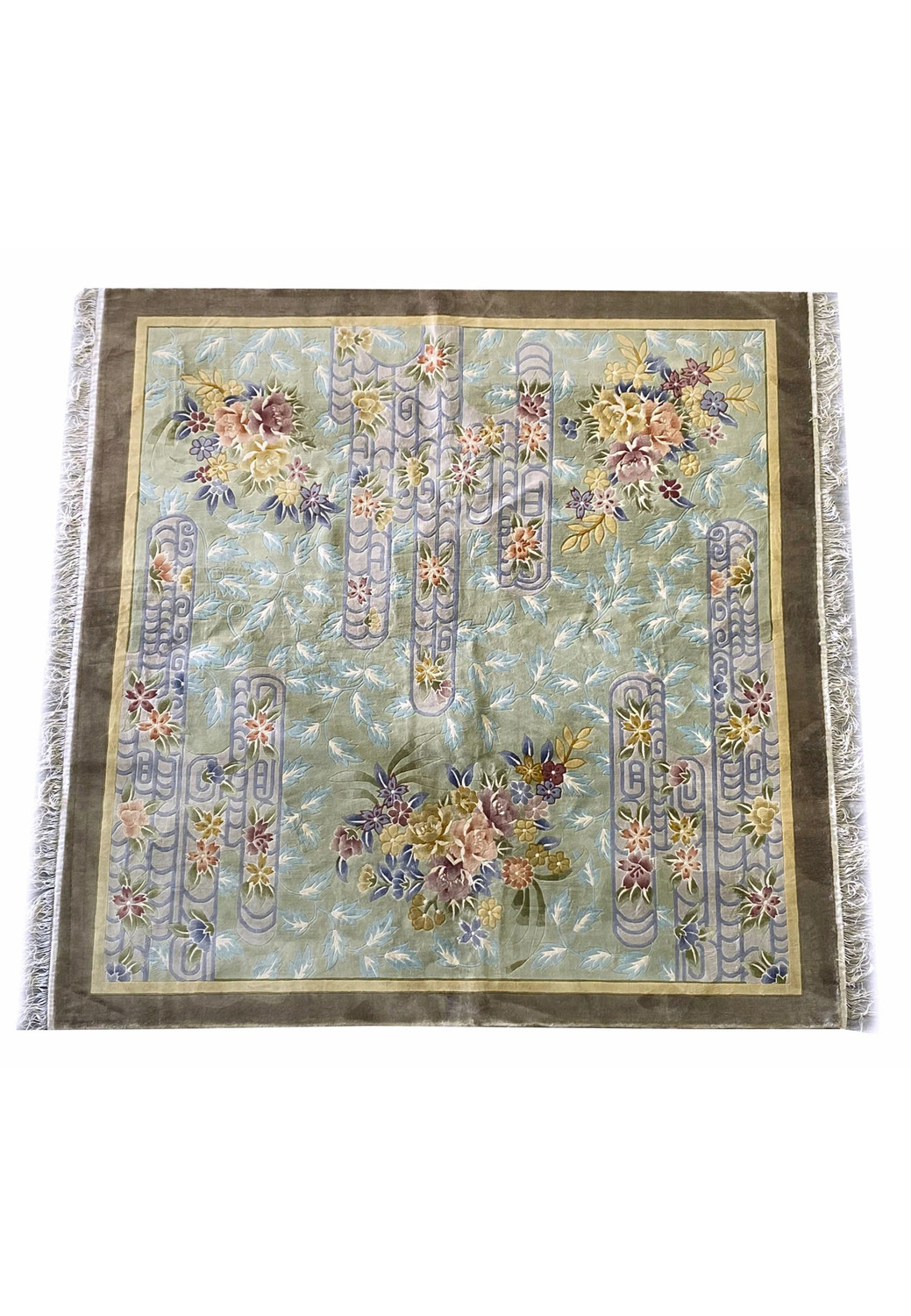 Top-down image of the Oriental Art Deco wool rug highlighting the symmetrical arrangement of pastel floral motifs and scroll lattice patterns on a muted green and blue field with deep taupe borders.