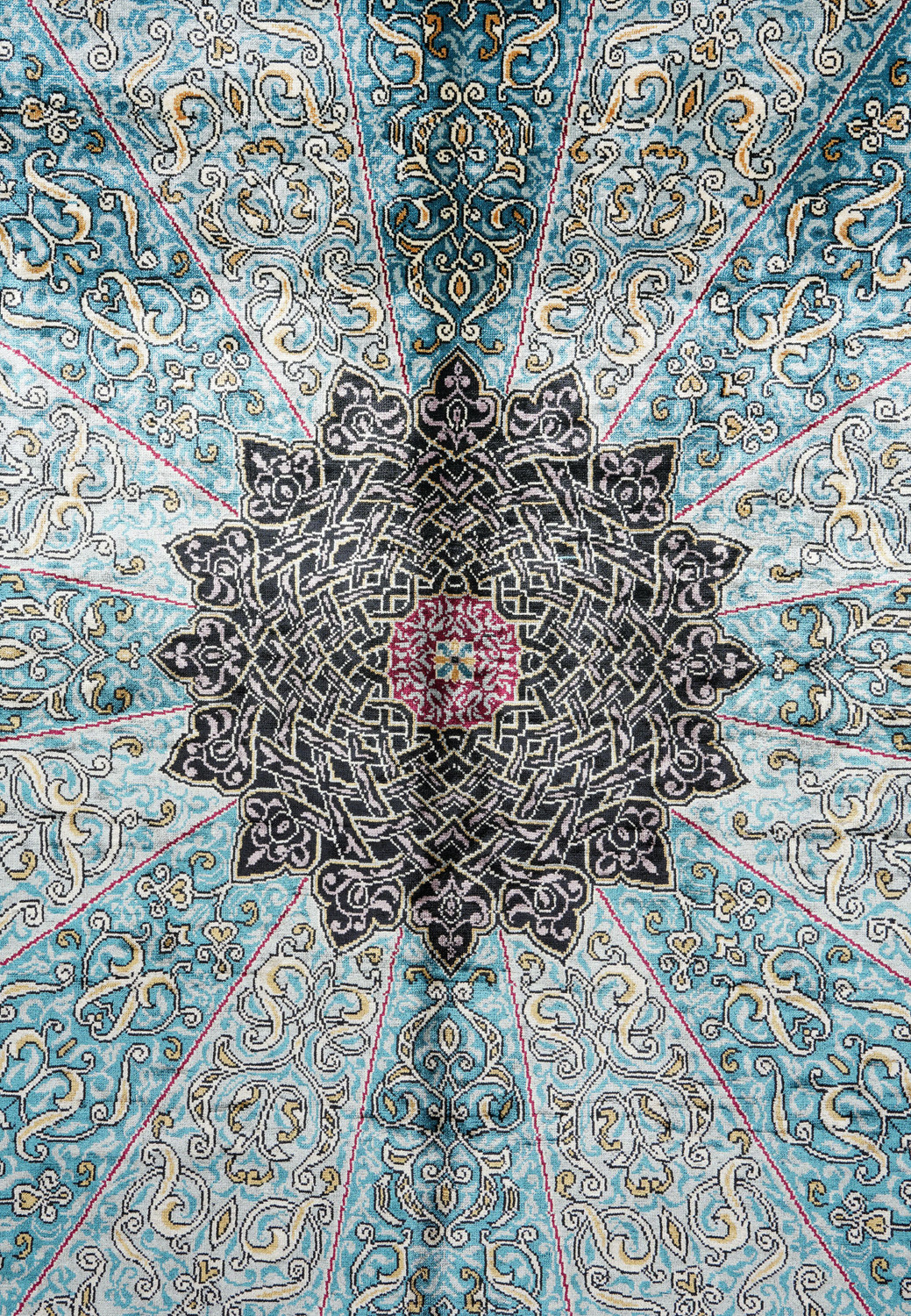 Detailed view of the intricate black and sky-blue medallion of the Chinese silk oriental rug Detailed view of the intricate black and sky-blue medallion of the Chinese silk oriental rug