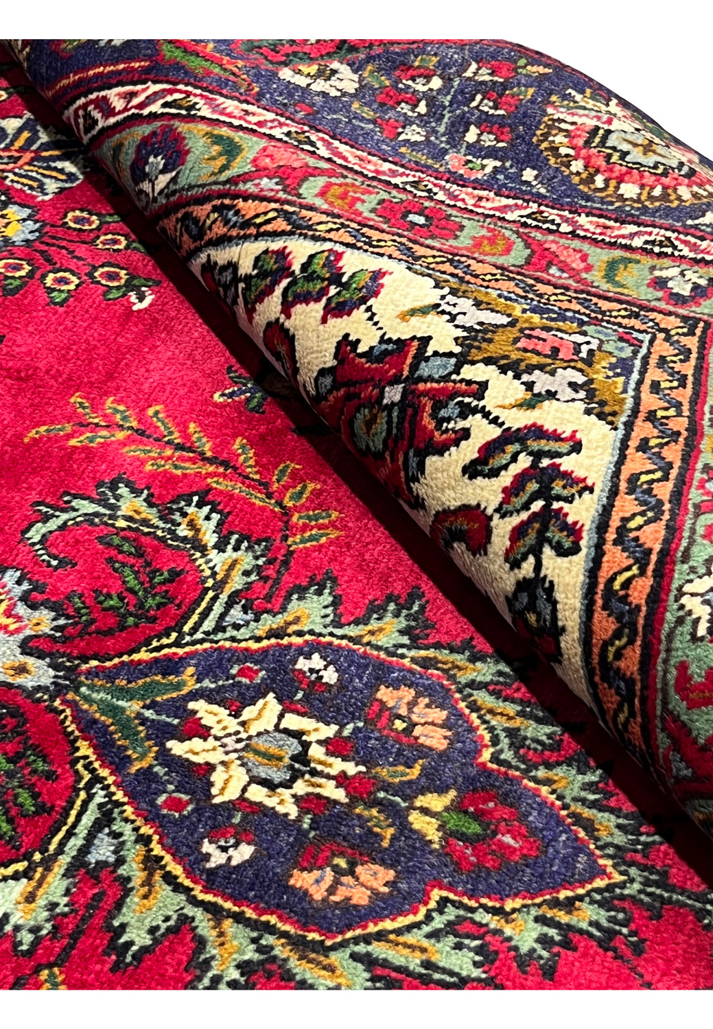 Rolled section of 8'5" x 12'9" Persian Tabriz rug showing soft wool texture and detailed weave