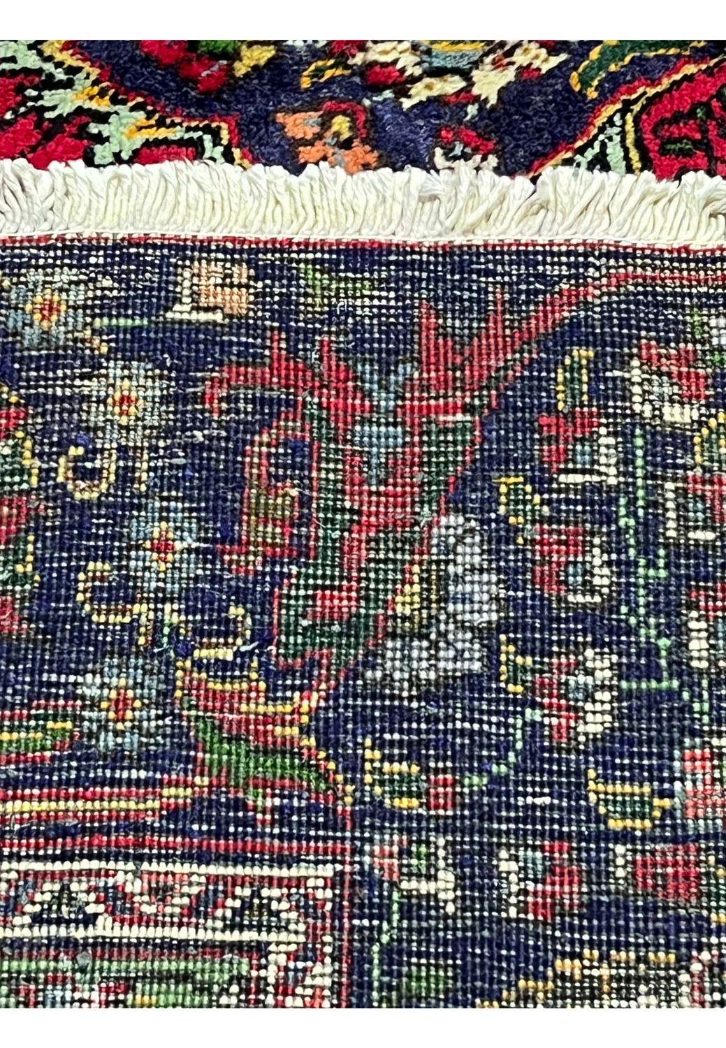 Backside of hand-knotted Persian Tabriz wool rug showing fine knot density and structure