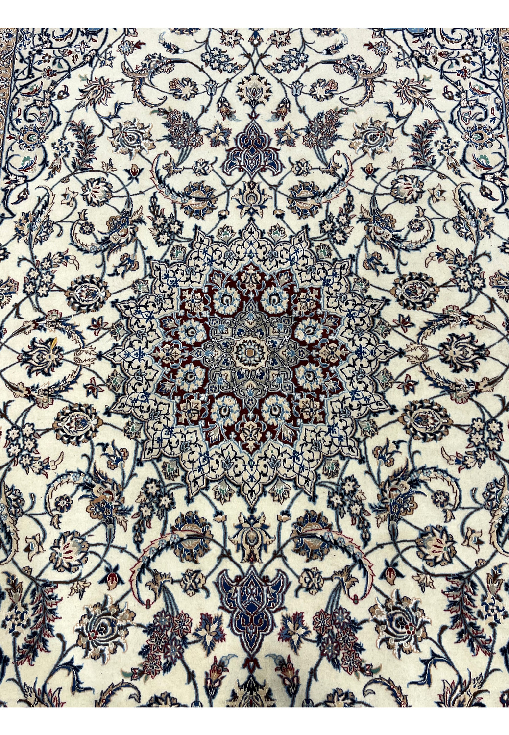 Elegant central medallion of Persian Nain 4 LA Habibian rug with blue, ivory, chestnut, and taupe tones forming a star-like floral composition.