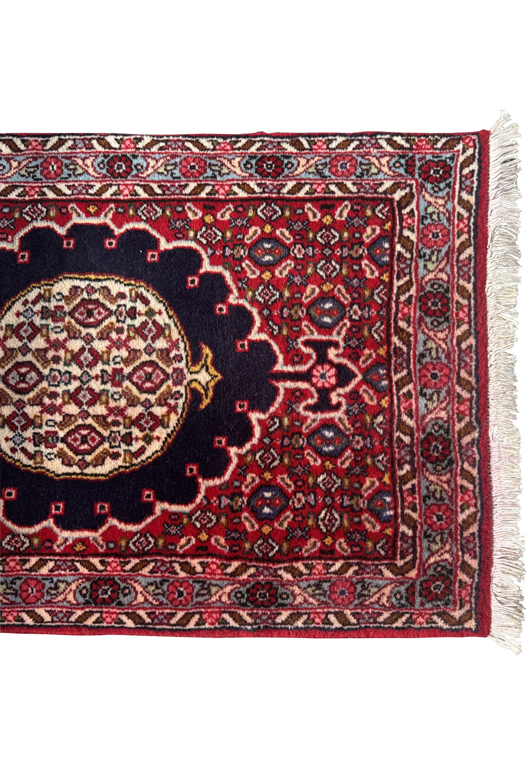 Close-up of Persian Bijar runner’s top corner showing crimson field, navy medallion, ivory border, and fine sky-blue floral detail.