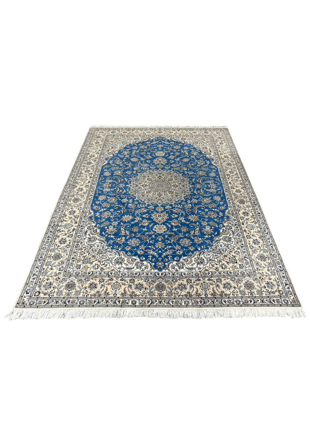Angled view of hand-knotted royal blue Nain 6 LA rug laid flat showing floral medallion design.