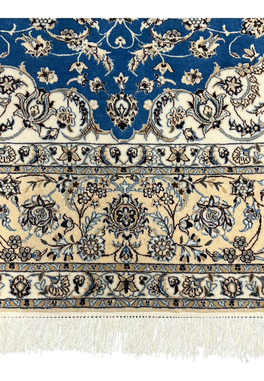 Lower edge view of Nain rug showing fringes and intricate floral border weaving.