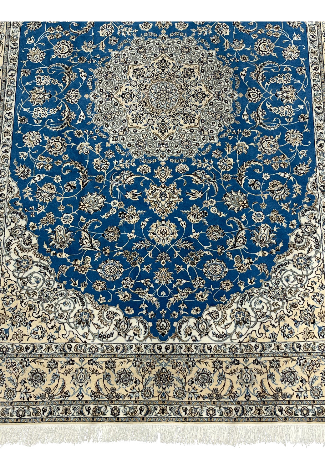 Close-up of ivory border and royal blue field with fine silk floral motifs on Persian Nain 6 LA rug.