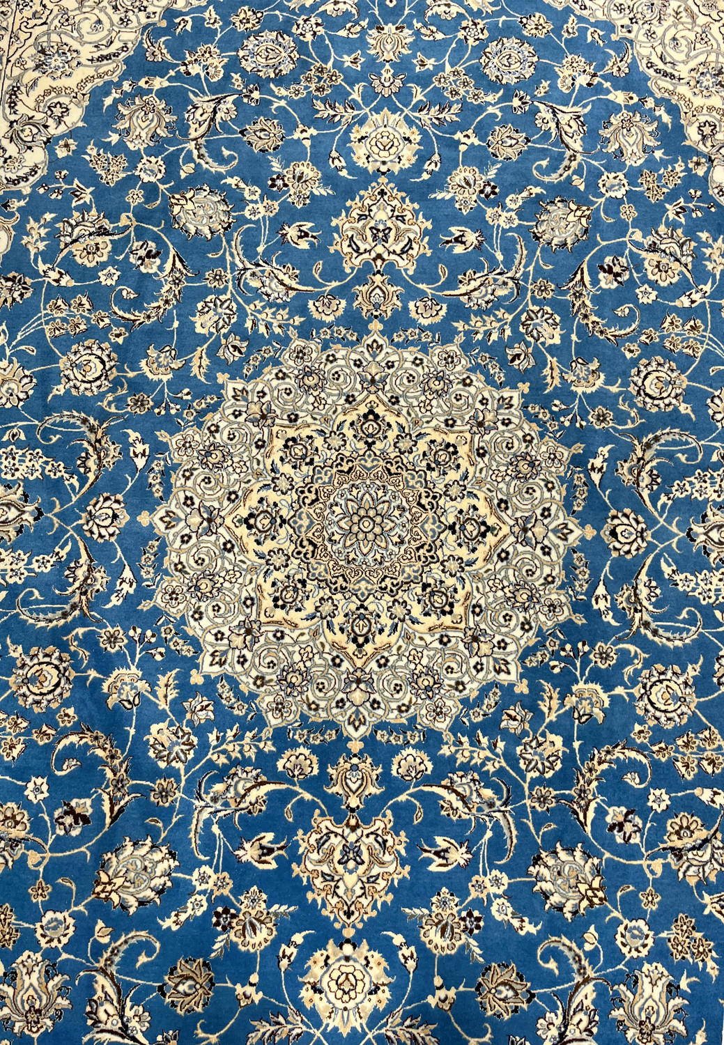 Close-up of central medallion showing fine silk detailing and precise weaving in royal blue Nain rug.