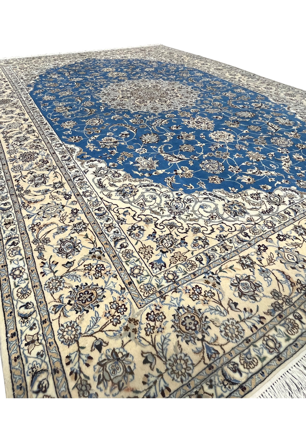 Close view of Nain 6 LA rug showing blue floral field meeting ivory vine border.