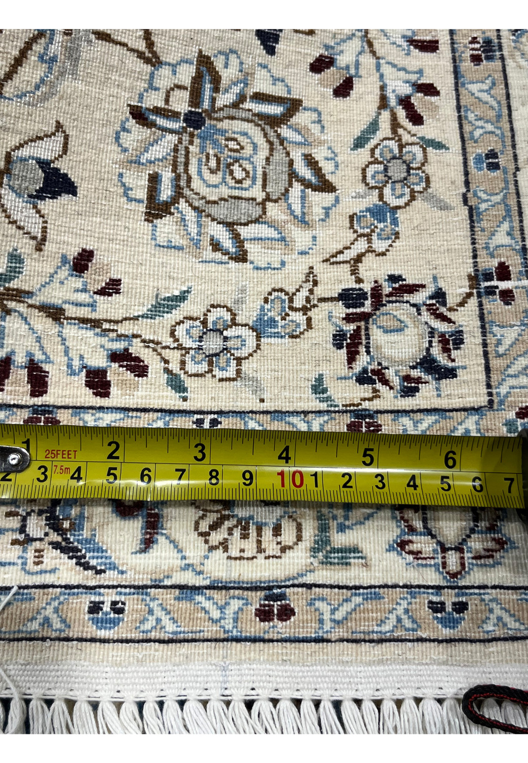 Close view of Persian rug knots on ivory back with measuring knot density.