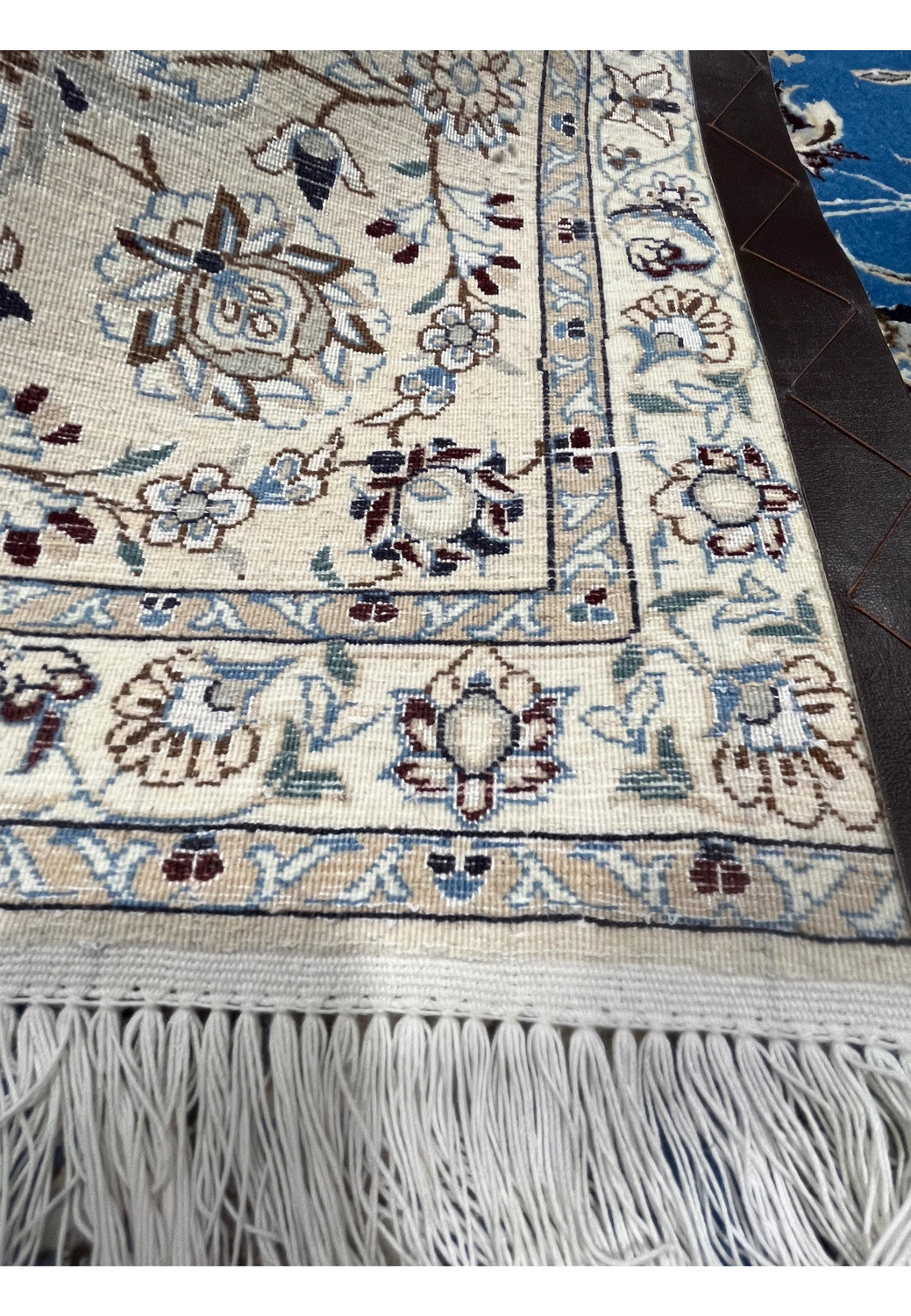 Back of Persian Nain rug showing dense hand-knotted foundation and ivory weft threads.