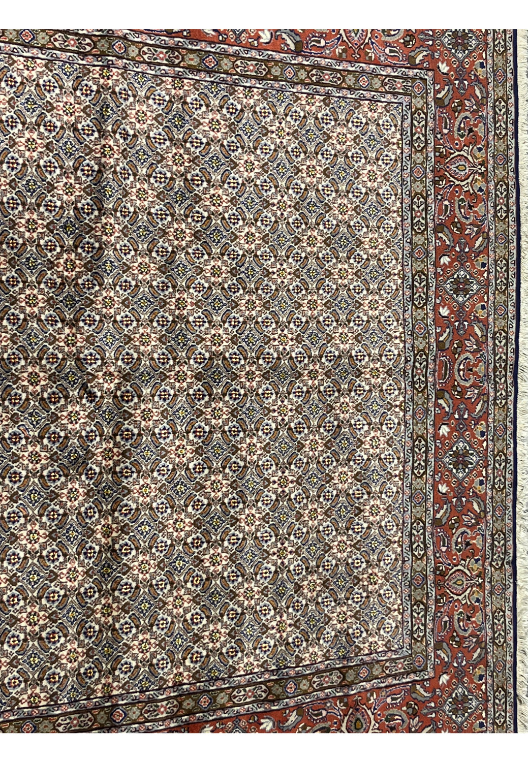 Close-up of all-over Moud Herati design with ivory, blue, brown, and red tones in fine wool texture.