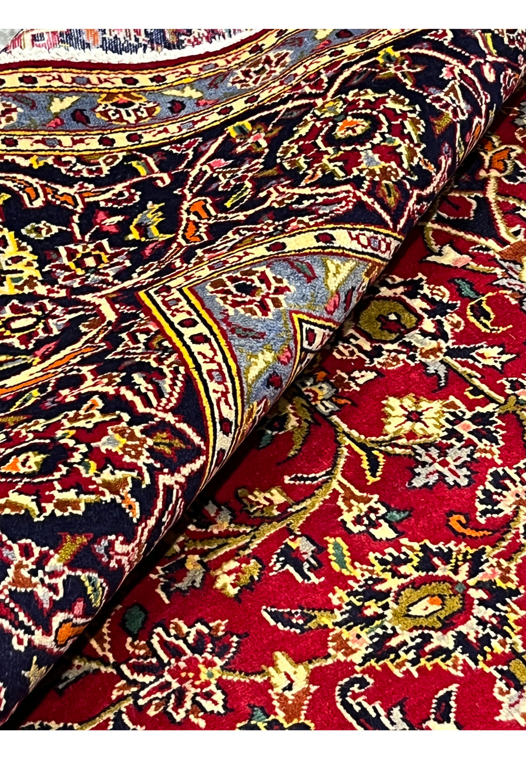 Rolled Persian Kashan rug 9x13 showing wool pile texture and handmade knots
