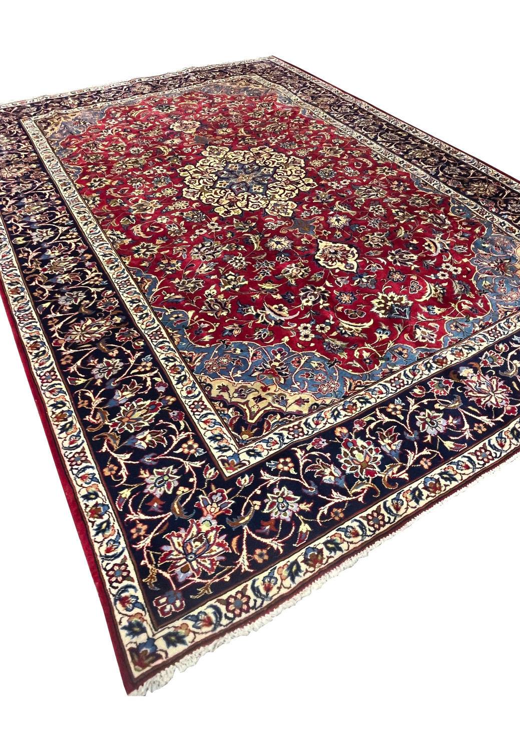 Angled view of 8'5 x 11'8 Persian Isfahan rug highlighting medallion, red field, and navy border.