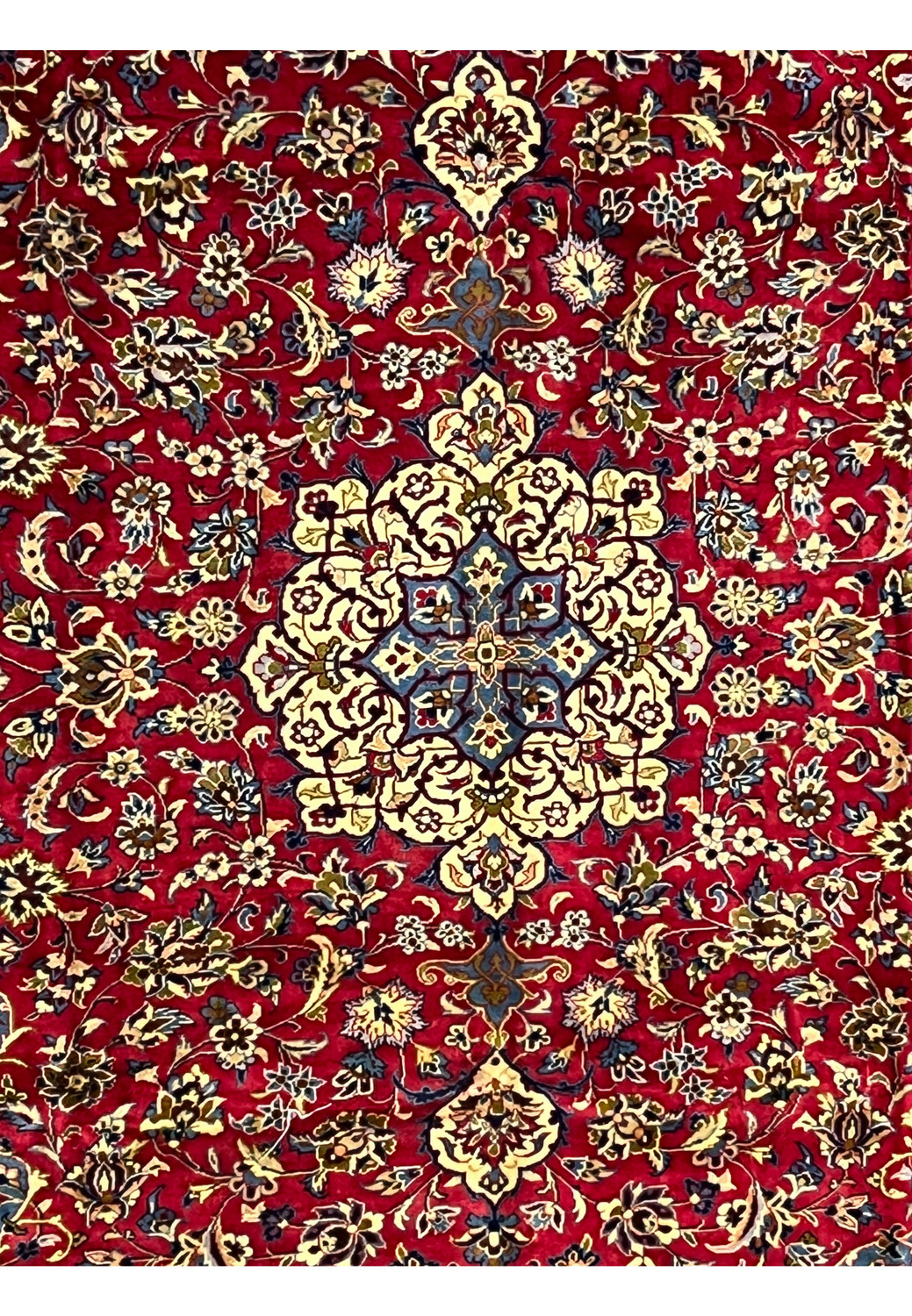 Closeup of 8'5 x 11'8 Persian Isfahan rug medallion with ivory, blue, and gold floral detailing.