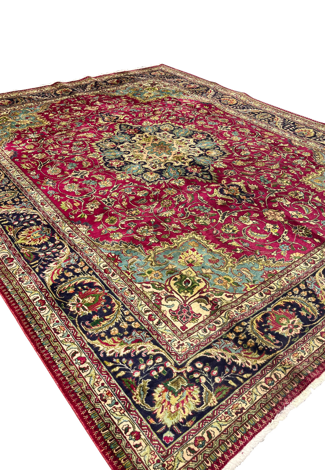 angled view of Persian Tabriz rug showing medallion depth, border contrast, and floral detailing