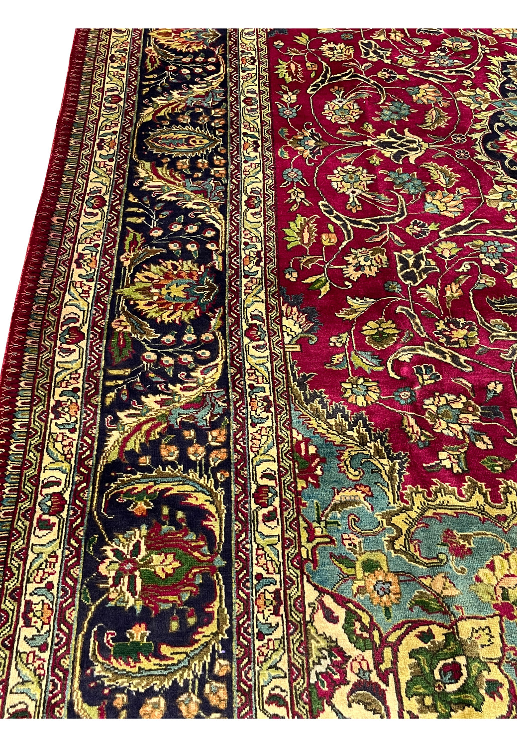 closeup of ornate Persian Tabriz border with navy ground, floral scrolls, and ivory guard stripes