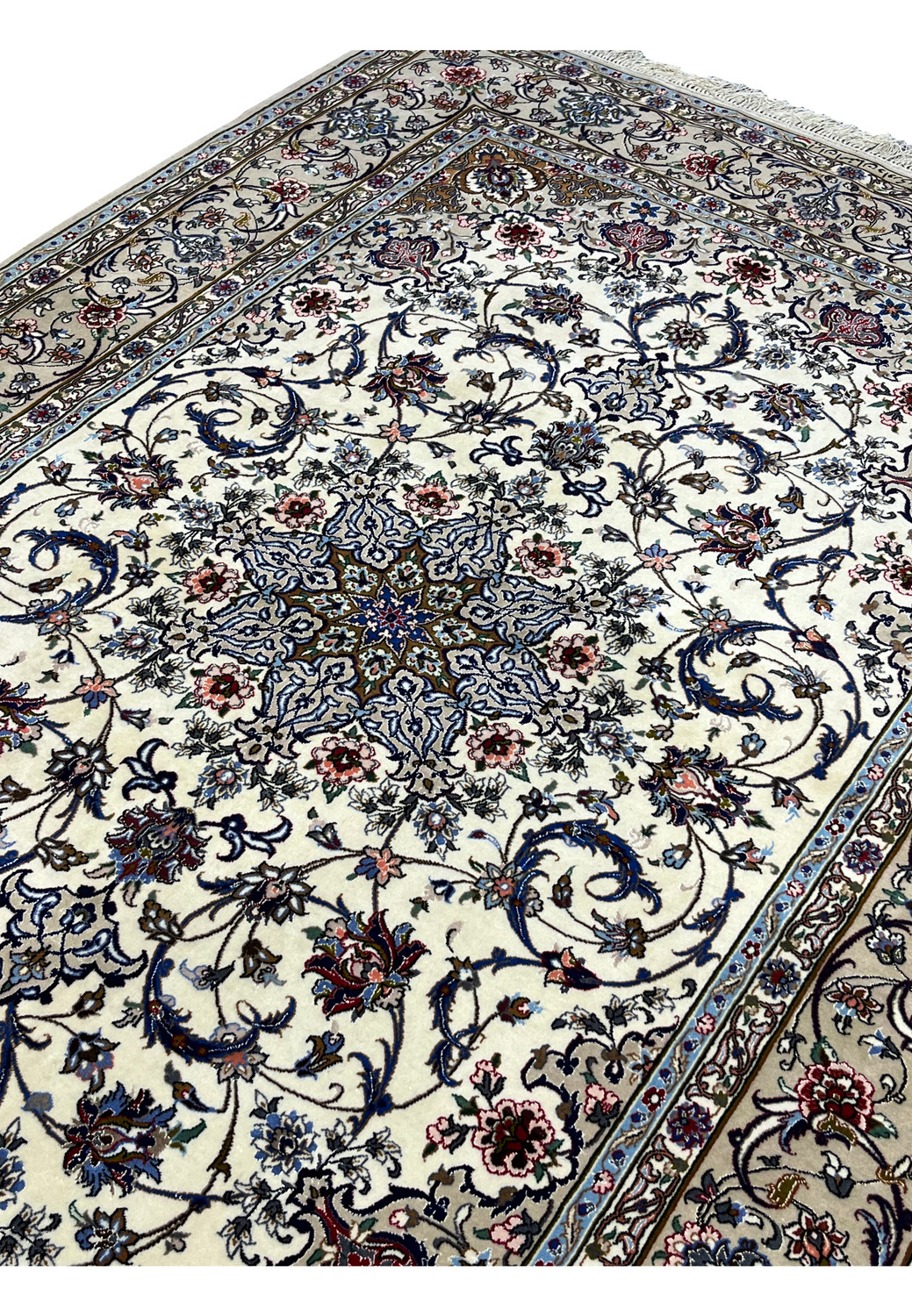 Angled field view of the signed Davari Persian Isfahan rug showing ivory background, navy vines, and detailed floral motifs in pink, blue, and burgundy.