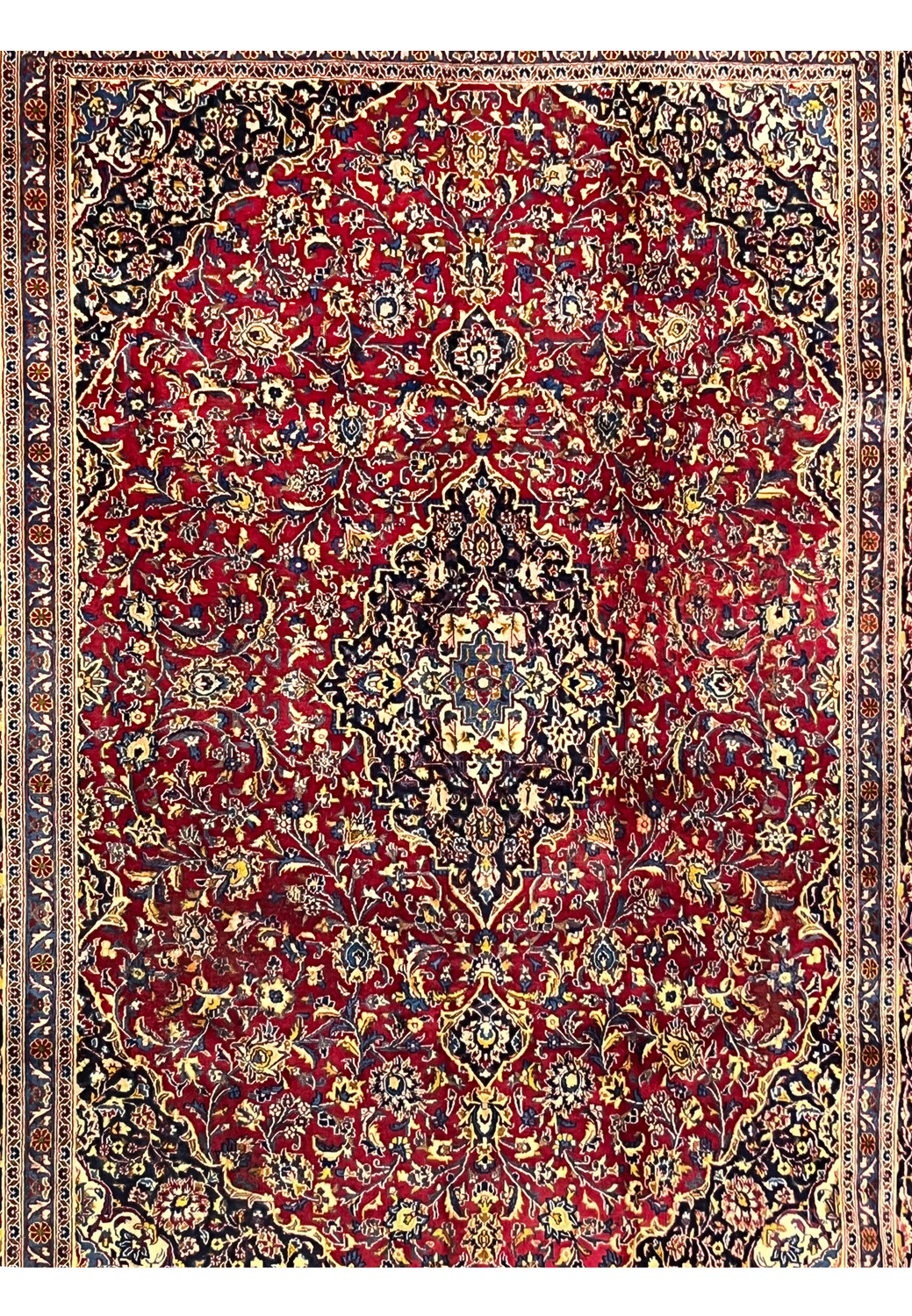 Midfield floral design of a patina Kashan rug with red background and worn areas.