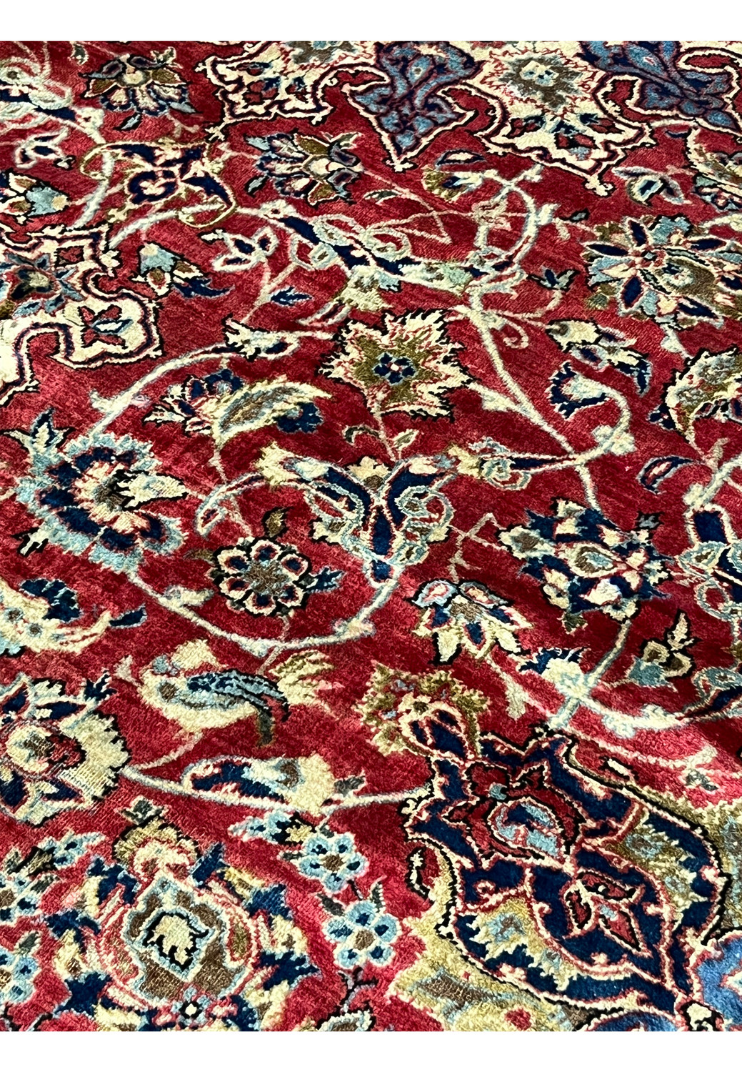 Field color close-up showing ruby red background with intricate floral clusters, vinework, and subtle vintage patina.
