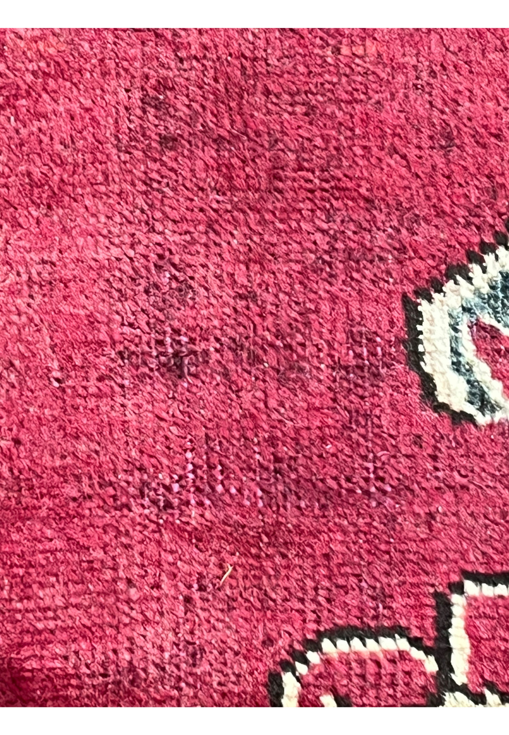 Low-pile section of patina vintage Persian Tabriz rug highlighting worn fibers, red wool field, and aged surface texture.