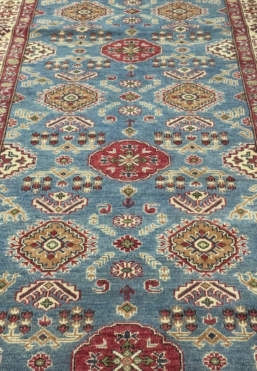 Field closeup showing sky-blue background and surrounding motifs.