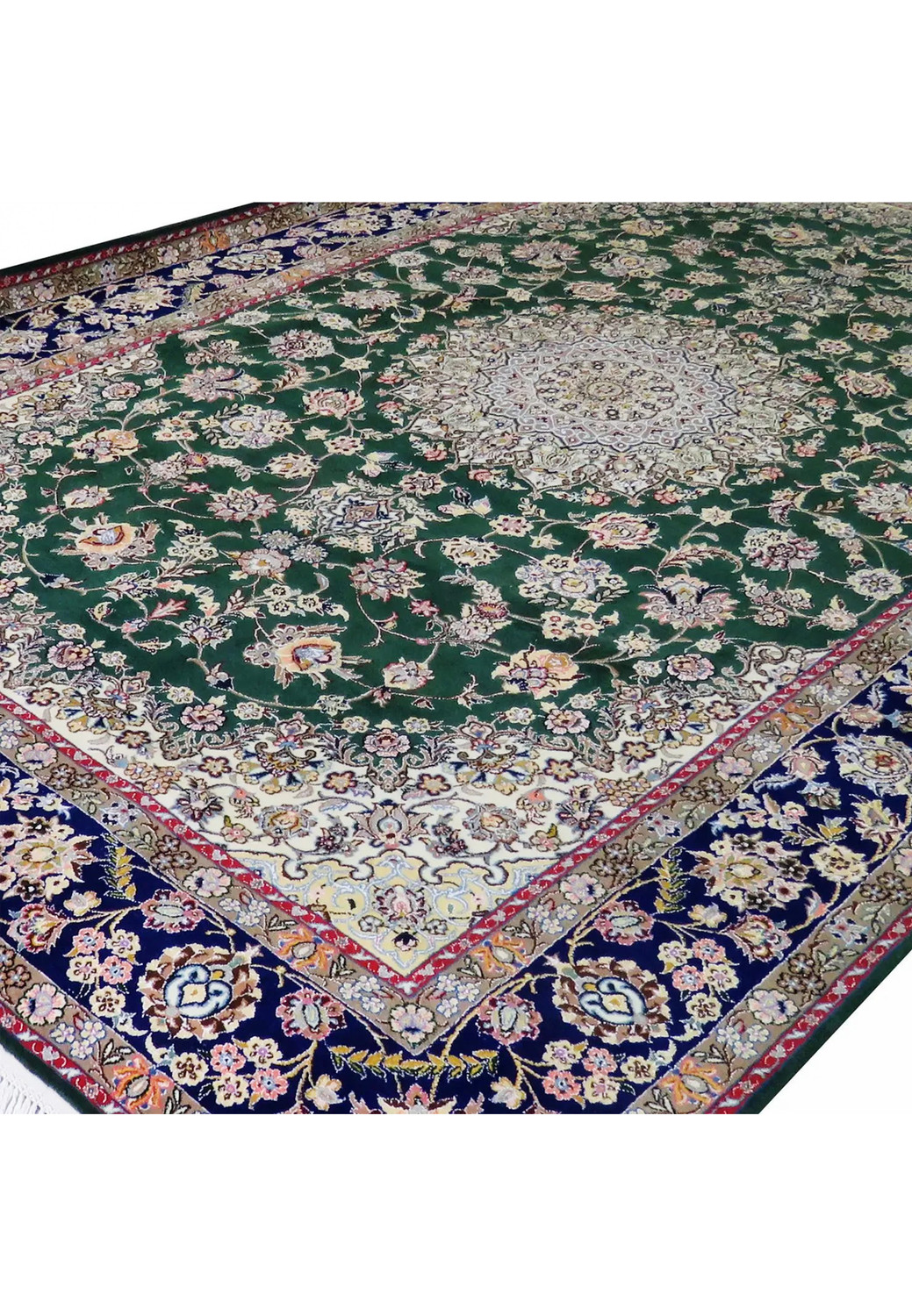 Angled view of 7x10 deep green Persian Nain 9LA rug showing navy border, ivory corner spandrels, and detailed floral vine pattern