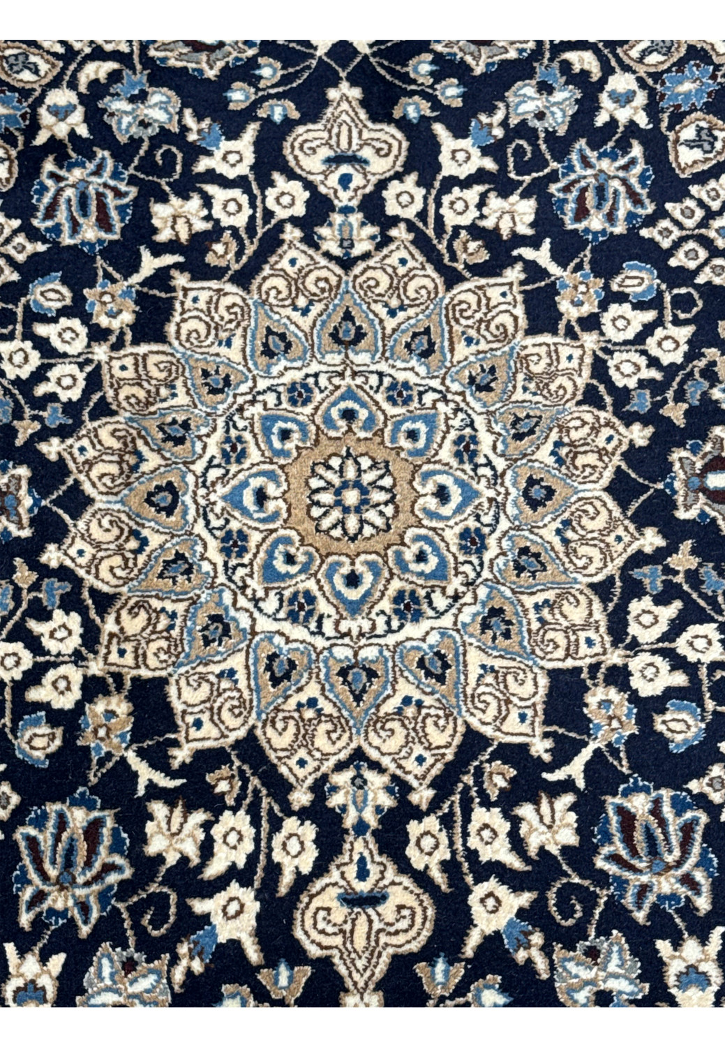Close up of ivory and beige medallion on navy Persian Nain rug with sky blue petals and soft gold detailing