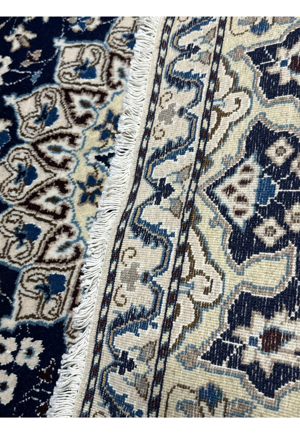 Backside of hand knotted Persian Nain rug showing cotton foundation and fine weave