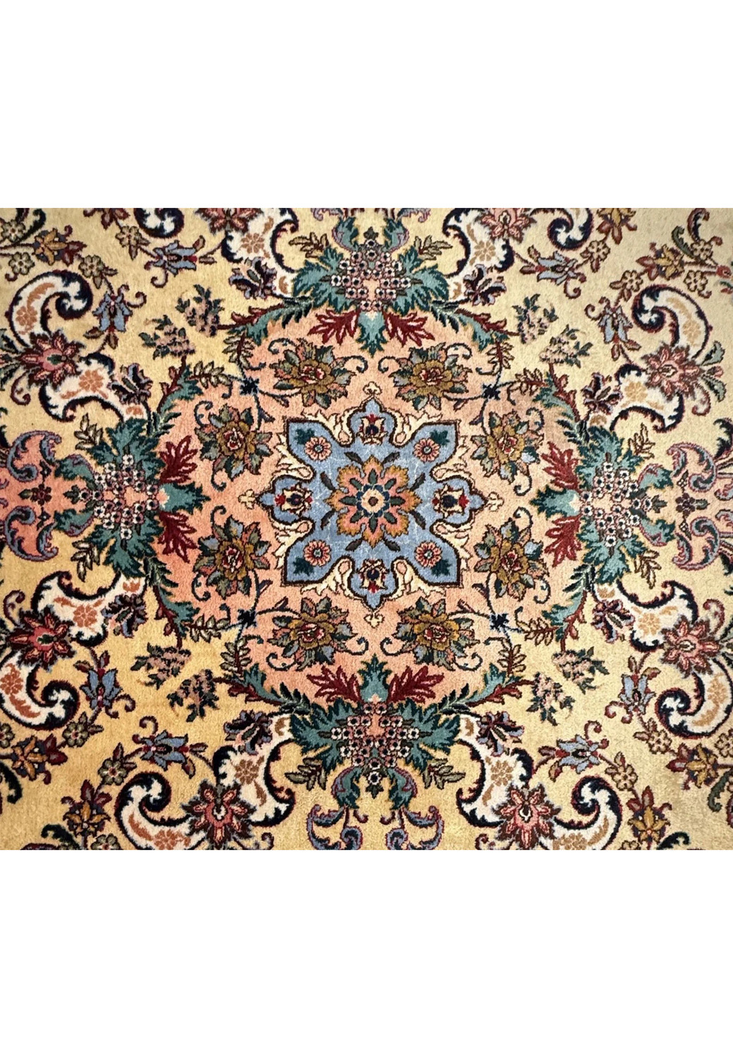 Close up of coral and slate blue central medallion with ivory and charcoal detailing on Persian Tabriz rug