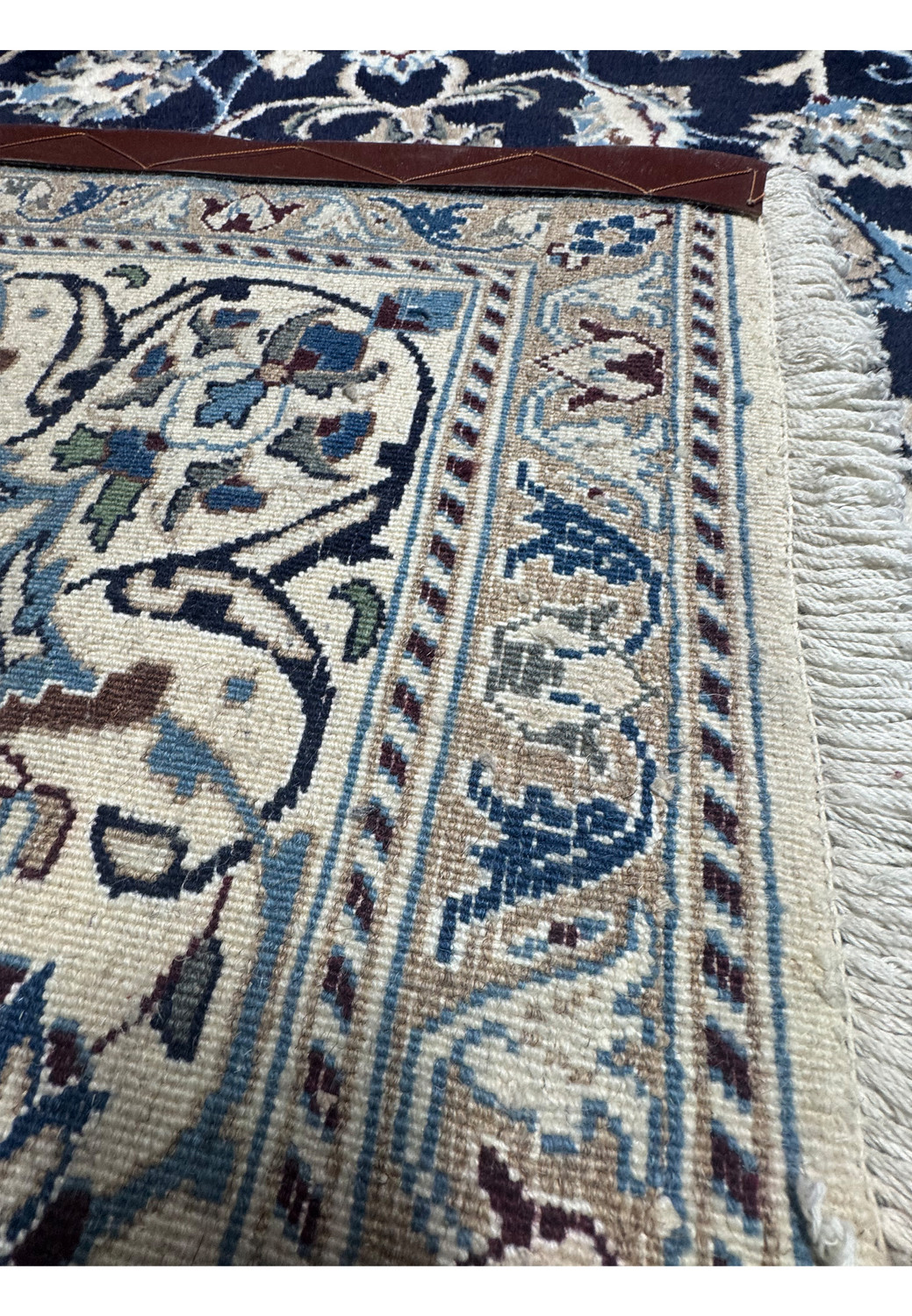 Backside of hand knotted Persian Nain rug displaying tight knot structure, even weave, and cotton foundation